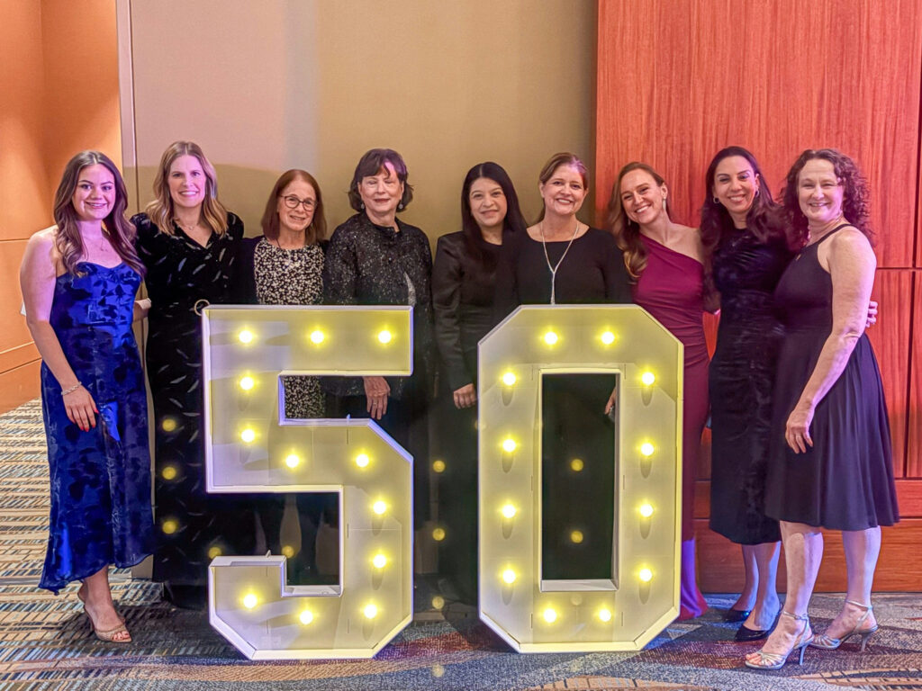 Group of attendees smiling for a photo in front of a large illuminated '50' sign at the 50th Annual SC Bar Convention.