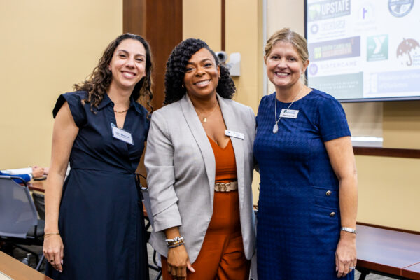 From left to right: Lana Kleiman of Charleston Legal Access, board member Lakesha Jeffries, and Anne Cagwood of Lowcountry Legal Volunteers, smiling and posing for the camera.