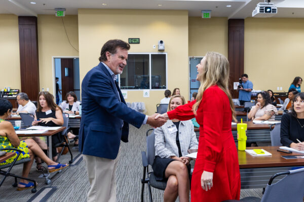 Two grantees shake hands while connecting during the networking event.